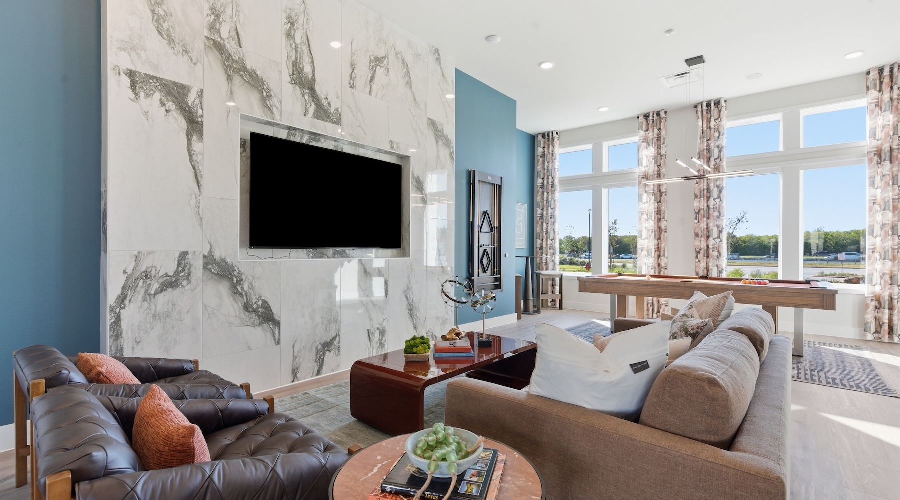 a lounge with a couch, tv and chairs